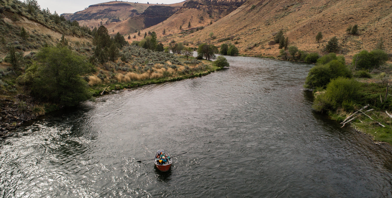 Fishing boat rows down Deschutes River.